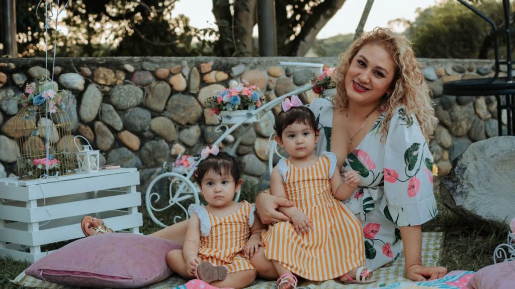 A joyful family picnic in La Dorada, Colombia featuring a mother and her two children outdoors.